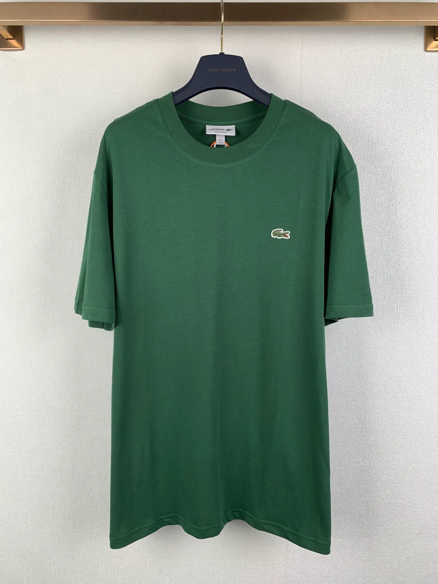 Lacoste crocodile logo short-sleeved T-shirt. Customized combed smooth plain cotton. Smooth and soft. Comfortable. Breathable. The pine dark green that has been deposited by time. The soft tones make people calm and calm. The iconic small crocodile pops up in the heart. The vivid logo contrasts with the calm background. The calm colors show the French style. Cut out the complexity and simplify it. Use solid color as the base and the logo as the print to show the texture and brand heritage in a low-key manner. Process 1: Use the car seal process. Make independent embroidered chapters through computer embroidery, then position them and sew them to fix them on the clothes. They have a strong three-dimensional effect, are strong and washable, and have stable quality. Process 2: The fabrics have been fermented and washed. They have a better hand feel and are not easy to deform, not easy to shrink, not easy to fade, and maintain long-term beauty. Accessories: Customized 1:1 Lacoste crocodile logo Customized 1:1 Lacoste trademark Version: Loose version Size: S M L XL